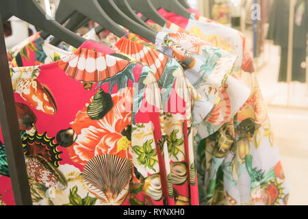 Colorful designer dresses on a rack in a department store. Stock Photo