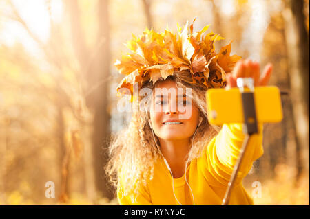 portrait of a young beautiful student girl on the background of the warm orange sun in the spring park. Beauty concept without makeup Stock Photo