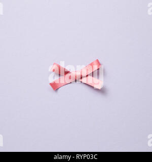 Decorative pink bow ribbon on purple background Stock Photo