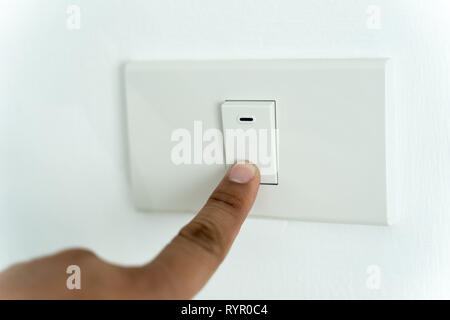 Close up of man finger is turning on or off on light switch Stock Photo