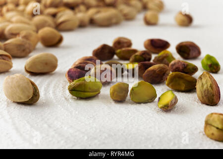 Pistachios isolated on a kitchen table, close up with white background Stock Photo