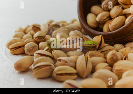 Pistachios on a kitchen table close up, white background Stock Photo