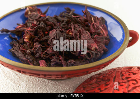 Red hibiscus tea in a bowl on a kitchen table, close up Stock Photo