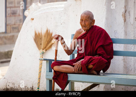 An old Buddhist monk sits on a bench at Shwe Yan Pyay monastery near Kalaw, Myanmar Stock Photo