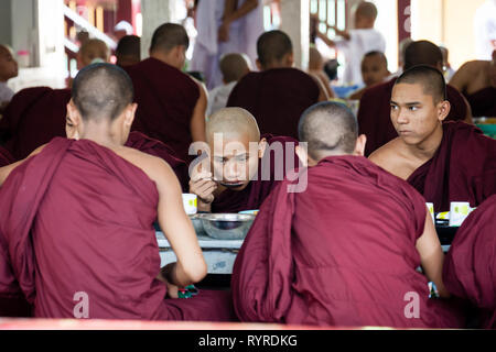 Buddhist monks queue for their lunch at Mahagandhayon Monastery located in Amarapura, Myanmar Stock Photo