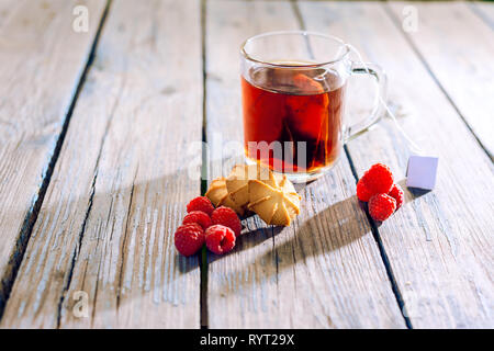 Red tea drink is boiled in a glass kettle on a gas stove, close-up