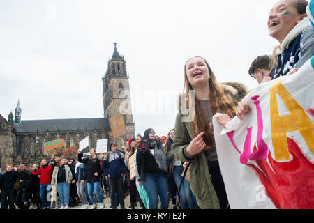 Magdeburg, Germany. 15th Mar, 2019. Students hop on the Fridays for Future rally. The Magdeburg Cathedral can be seen in the background. In Magdeburg, pupils and students gathered in the morning with banners and loud music to demonstrate for better climate protection. Under the motto #FridaysForFuture, around 1700 rallies in around 100 countries worldwide are on the programme, including various German cities. Credit: Klaus-Dietmar Gabbert/dpa-Zentralbild/ZB/dpa/Alamy Live News Stock Photo