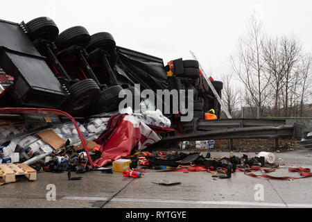 Enns, Upper Austria, Austria - March 15 2019: Large truck flipped over in a heavy traffic accident on the A1 Motorway called Westautobahn in German near Enns in Upper Austria. The truck is upside down  after the crash and the cargo has been scattered on the motorway. Credit: Dietmar Rauscher/Alamy Live News Stock Photo