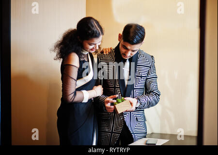 Lovely indian couple in love, wear at saree and elegant suit, posed on  restaurant. Woman tied tie on her man Stock Photo - Alamy