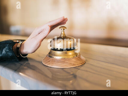 Hand ringing service bell on hotel reception desk Stock Photo