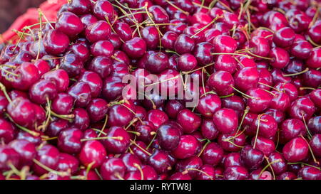 Plenty of purple dwarf cherry on the basket.  It is closely related to the sweet cherry but has a fruit that is more acidic and has greater nutritiona Stock Photo