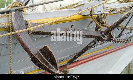 The anchor and chains on the side of the ship the ship is white in color Stock Photo