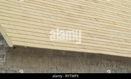 Closer look of the wooden cabin house it has a big roof with wooden brown shingles Stock Photo