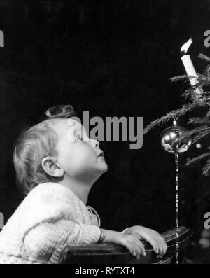 Christmas, people, infant standing in front of Christmas tree, 1934, Additional-Rights-Clearance-Info-Not-Available Stock Photo