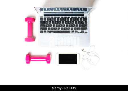 Flat lay to composition with fitness equipment pink dumbbels, computer, mobile phone, headphones and space for text on white background. Sport, office Stock Photo