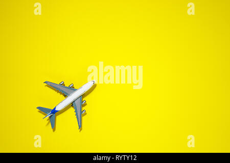 Minimal layout with model airplane on yellow background. Directly above. Travel vacation summer concept. top view, flat lay composition. Stock Photo