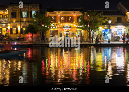 Hoi An, Vietnam - November 13, 2018: the nightlife of the riverside with restaurants and shops decorated with lanterns and the colorful reflections. Stock Photo