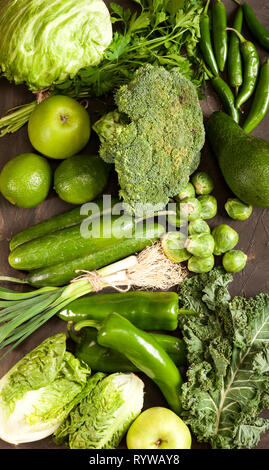 Green health food fruits and vegetables. Kale leaves broccoli cucumber lime apple kiwi avocado lettuce brussels sprouts parsley hot pepper chilli garl