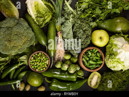 Green health food fruits and vegetables. Kale leaves broccoli cucumber lime apple kiwi avocado lettuce brussels sprouts parsley hot pepper chilli garl
