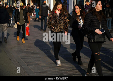 Istanbul, Turkey - March 6 , 2019 : Young women in fashionable  clothes, one of them is wearing a leopard patterned jacket and other people. Stock Photo