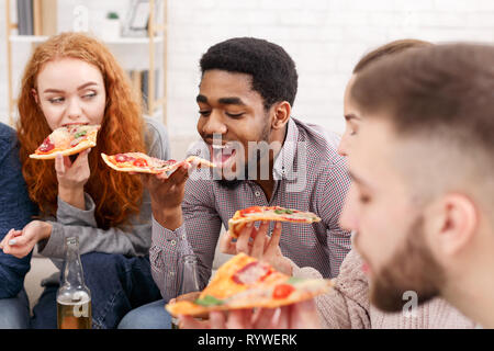 Pizza time. Friends eating and drinking beer at home Stock Photo