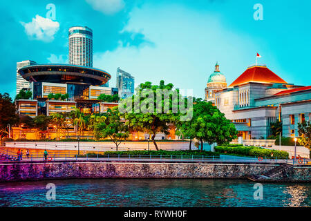 Parliament and Old Supreme Court and New Supreme Court Building at Boat Quay in Singapore at night. It is illuminated Stock Photo