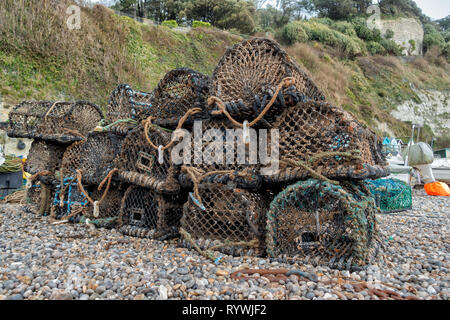 Crab traps sit on the shingle beach at Beer, Devon. Stock Photo