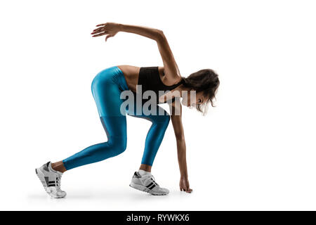 Young african woman preparing to start run isolated on white studio background. One female runner or jogger. Silhouette of jogging athlete. Stock Photo