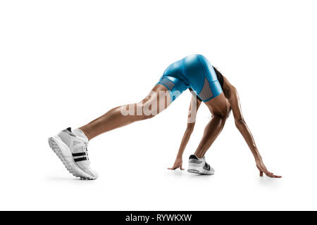 Young african woman preparing to start run isolated on white studio background. One female runner or jogger. Silhouette of jogging athlete. Stock Photo