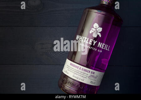 LONDON - MARCH 13, 2019: Whitley Neill Rhubarb Ginger Gin in purple glass bottle on dark wood background Stock Photo