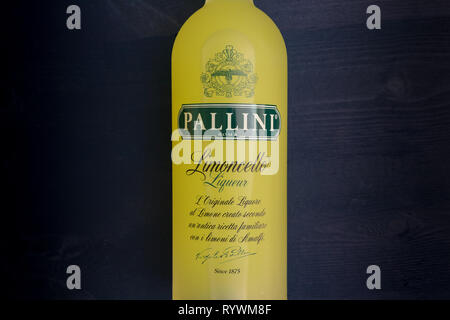 LONDON - MARCH 13, 2019: Pallini Limoncello lemon liqueur in yellow glass bottle on dark background Stock Photo