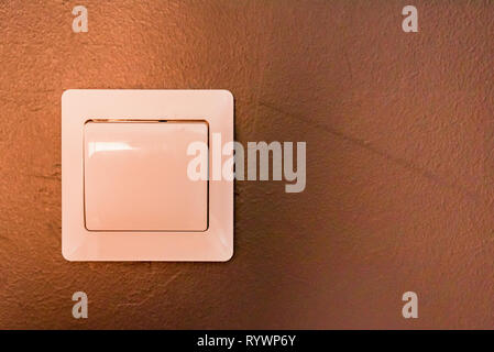 White modern light switch on beige wall close Stock Photo