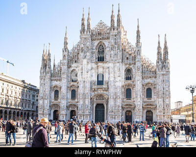 MILAN, ITALY - FEBRUARY 24, 2019: tourists on square Piazza del Duomo in front of Milan Cathedral (Duomo di Milano) in Milan city in morning. This Bas Stock Photo