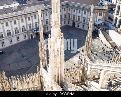 MILAN, ITALY - FEBRUARY 24, 2019: above view of people near Palazzo Reale on Piazza del Duomo from Milan Cathedral (Duomo di Milano) roof in morning.  Stock Photo