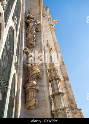 MILAN, ITALY - FEBRUARY 24, 2019: decorative sculpture on roof of Milan Cathedral (Duomo di Milano) in Milan in morning. This Basilica is the largest  Stock Photo