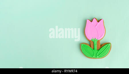 Gingerbread in the form of a tulip on a blue background. Spring, Easter, minimalism. Stock Photo