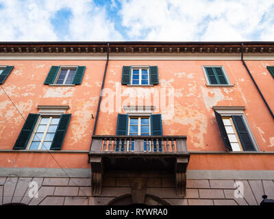 Travel to Italy - bottom view of red apartment house on street via Giovanni Battista Moroni in Lower Town (Citta Bassa) of Bergamo city, Lombardy in s Stock Photo