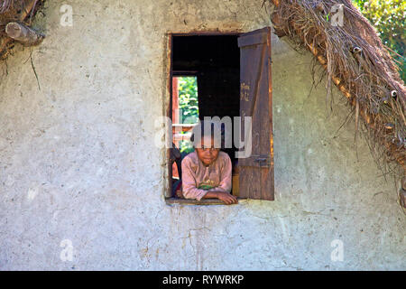 Portrait of young girl in the window Manakara, Madagascar. Stock Photo