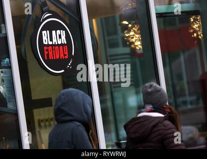 Bucharest, Romania - November 20, 2018: Several people walk in front of a showcase with Black Friday advertising on a street in Bucharest. Stock Photo