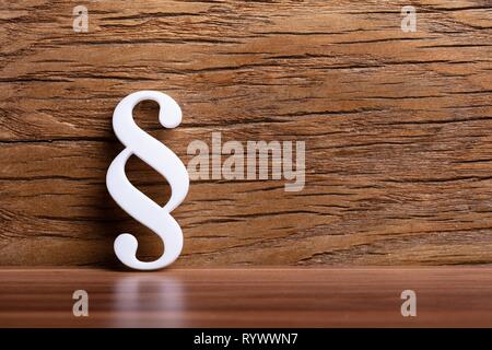White Paragraph Sign Leaning On Wooden Wall Stock Photo
