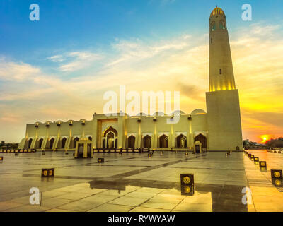 Scenic Doha Grand Mosque with a minaret at sunset light reflecting on the outdoor pavement. Qatar State Mosque, Middle East, Arabian Peninsula in Stock Photo