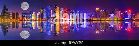 Banner panorama of Doha West Bay skyline lighting by night reflecting in Doha Bay. Modern skyscrapers of Doha with full moon, Qatar, Middle East Stock Photo