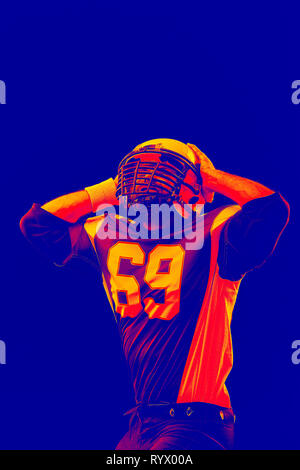 Isolated American football player rejoices in victory. Special effect neon light. Stock Photo