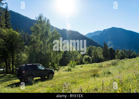 Travel concept with big 4x4 car against sunset and mountains. photo of offroad wheel Stock Photo