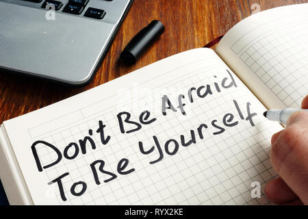 Dont be afraid to be yourself handwritten in a note. Motivation quote. Stock Photo