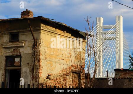 Bucharest, Romania - December 11, 2016: An abandoned house is seen in front of 'Basarab Bridge', the longest and the highest suspension bridge in Buch Stock Photo