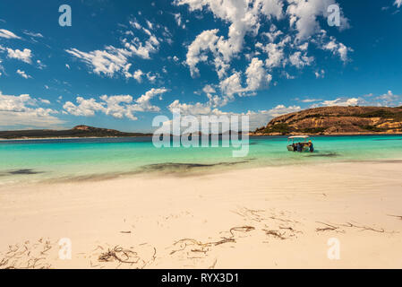 Hellfire Bay, Esperance, Australia--February 9, 2018. A man and a woman are pushing a boat while knee deep in the water of beautiful Hellfire Bay in E Stock Photo