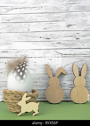 Easter background with Easter egg and Easter bunnies  isolated on green in front of wood Stock Photo