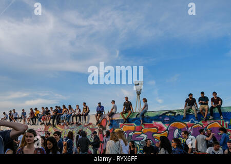 Berlin, Germany, may 2017: Many young people sitting on wall in crowded park (Mauerpark) at 'fete de la musique' in Berlin, Germany. Stock Photo