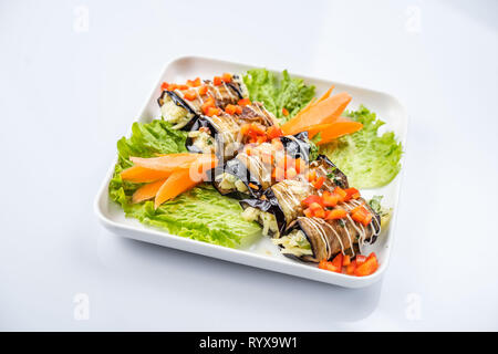 eggplant rolls with nuts on a white plate Stock Photo